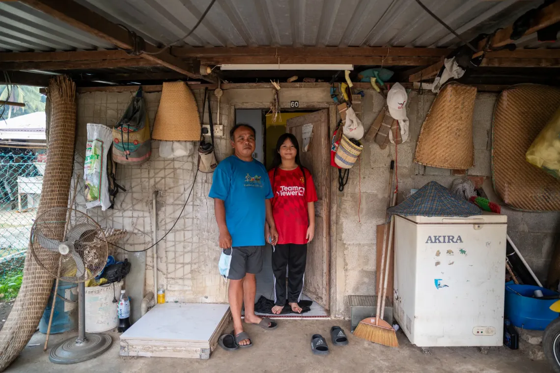 Eva stands with her uncle at the entrance of their home.