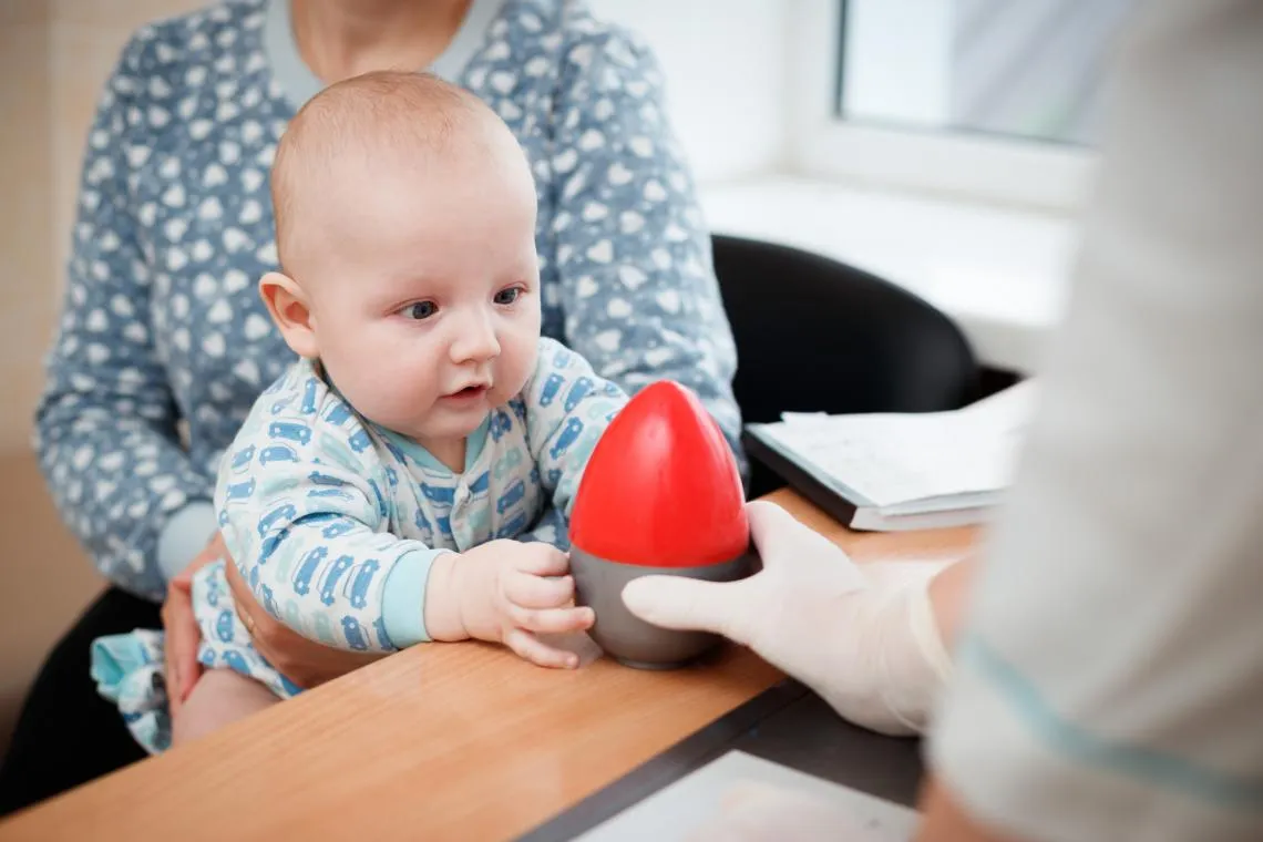 A baby is entertained by a nurse in Ukraine.