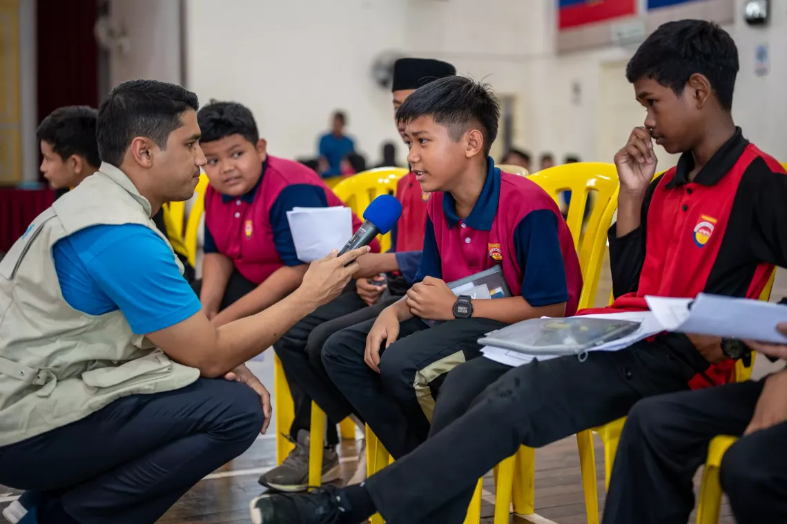 Sufyan engaging with students during a DRR session at Sekolah Kebangsaan Sri Rantau Panjang 2, Kelantan. Many of these children have endured devastating floods, losing not only their cherished toys and school supplies but, in some cases, even critical documents like birth certificates and ID cards. At evacuation centers, they often struggle with a lack of basic necessities, compounding their distress.