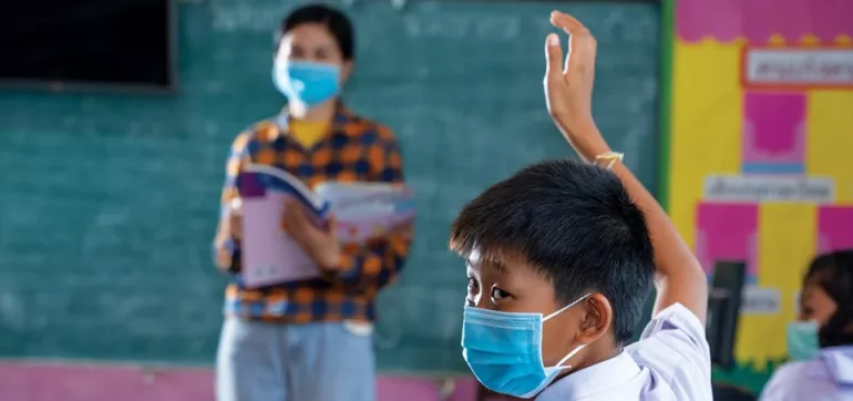 A boy raises his hand in classroom