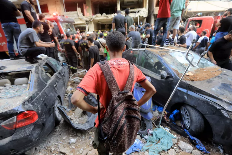 a boy is looking at the rubble in Beirut
