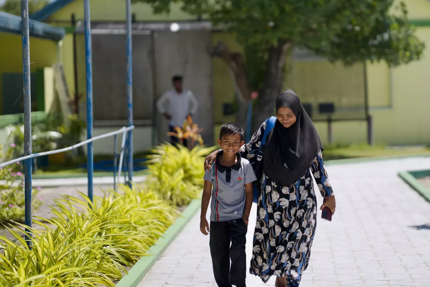 A child walking home from school with his mother
