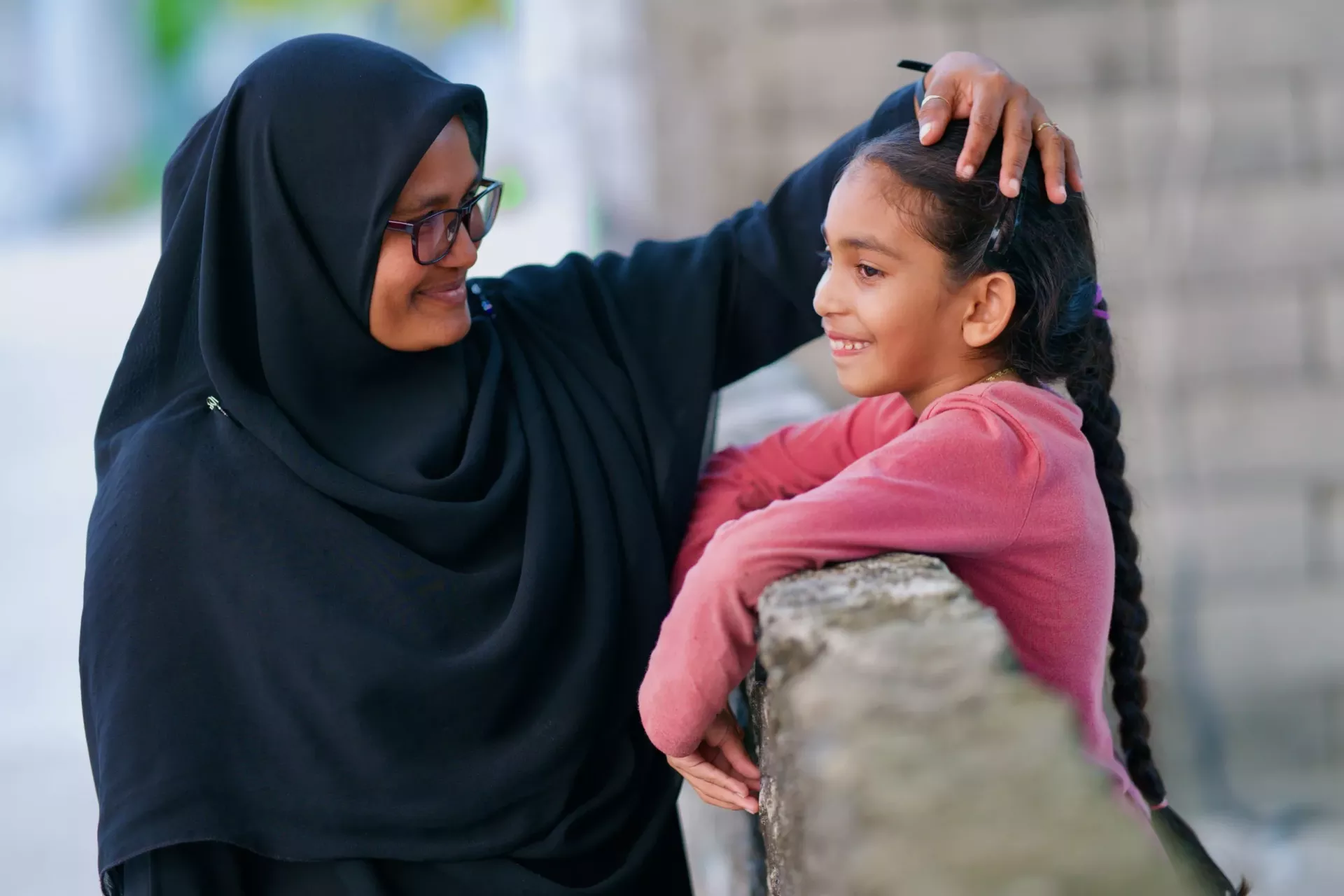  A mother patting her young daughter on the head.