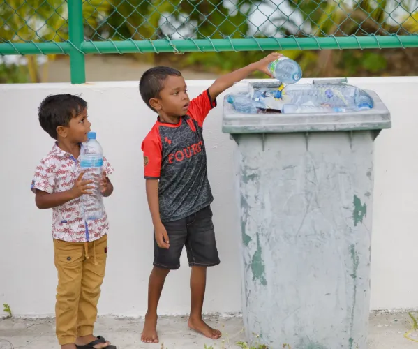 Two children recycling 