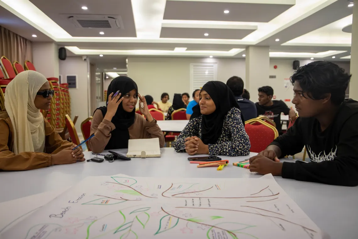 A group of young people working around a table 