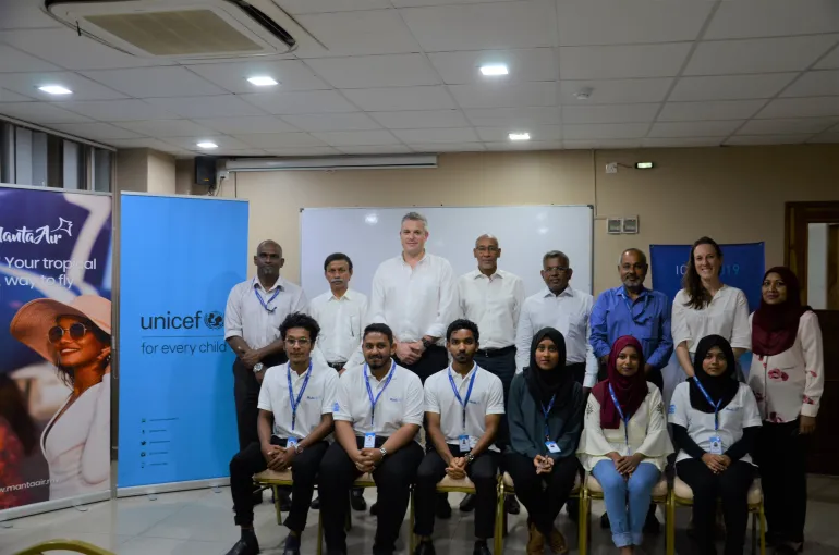 apprentices and staff of unicef and manta air stand for a photo