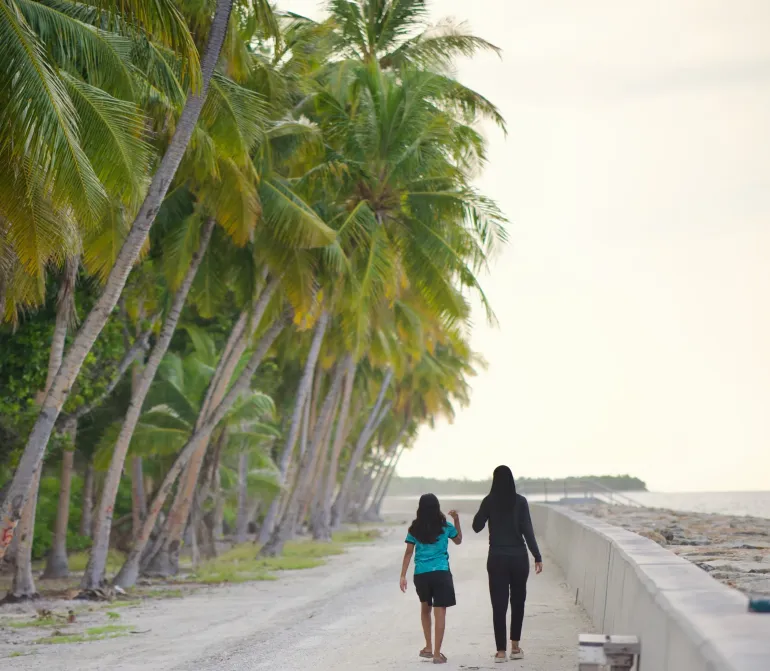 Two girls walking on an island road in Maldives 