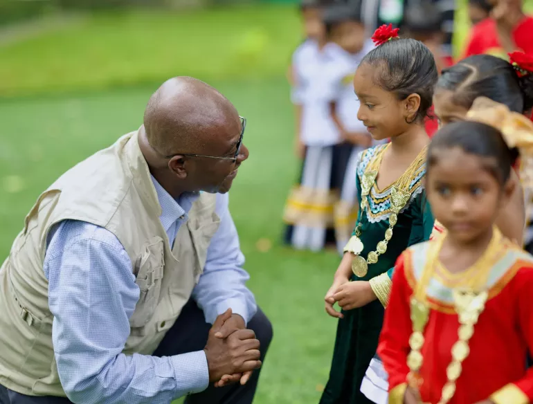 UNICEF Representative, Dr. Edward Addai talking to a little girl dressed in Maldivian dress