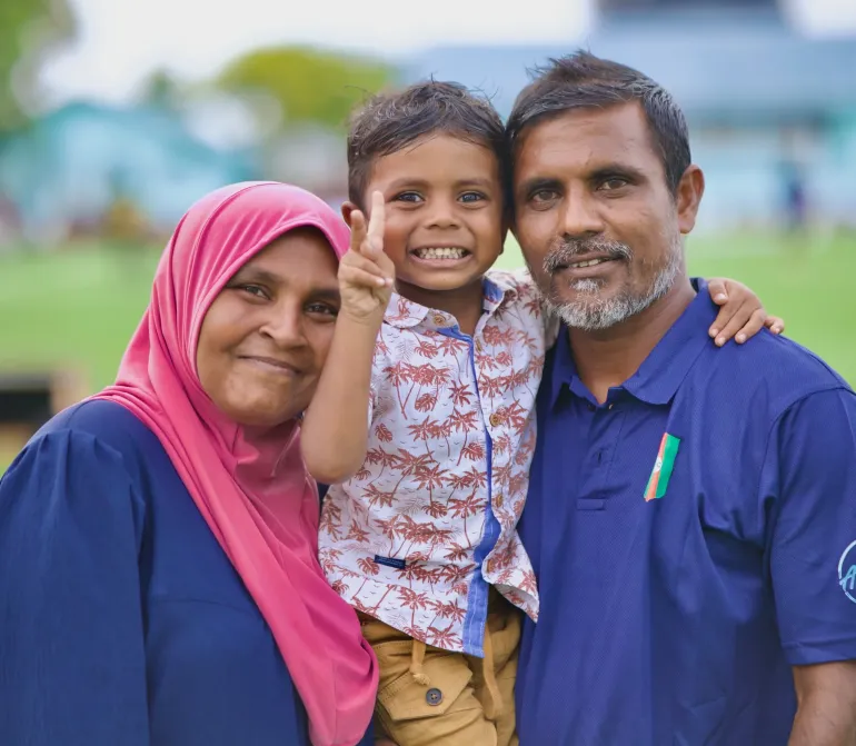 A family of three looking at the camera 