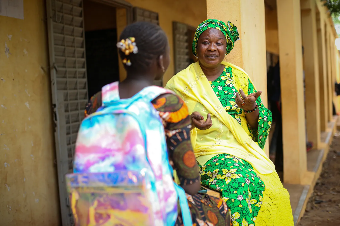 a teacher listens to a student in the school yard