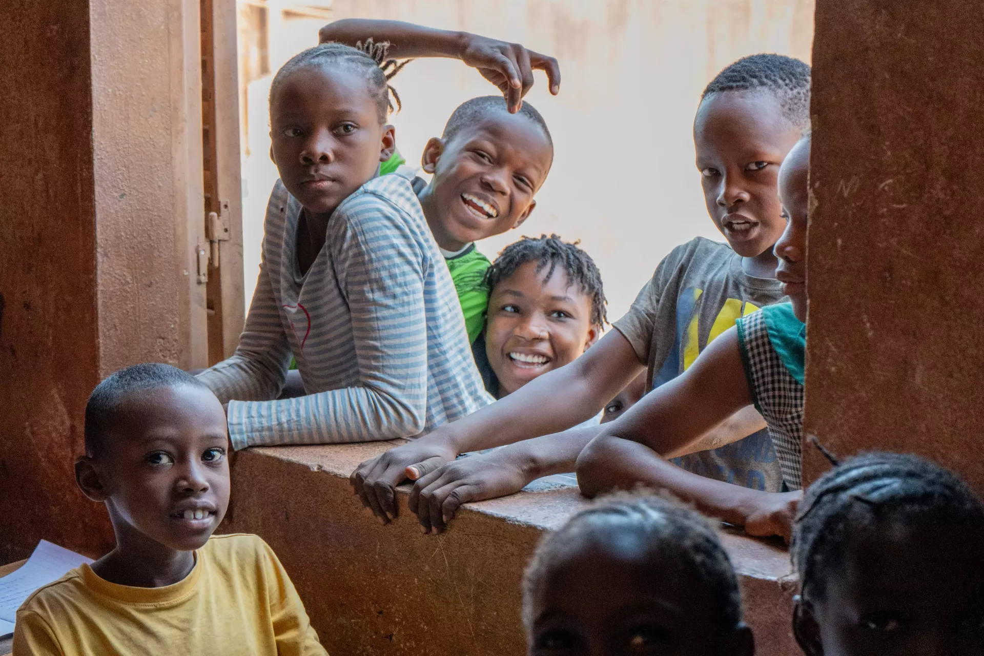 Girls and boys laugh at their classroom window