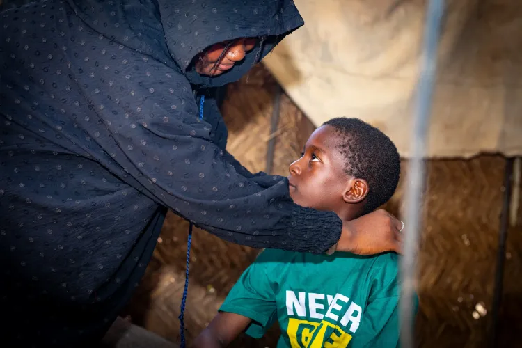 Mahamadou, 10, listening intently to his mother&rsquo;s advice before leaving for school.  