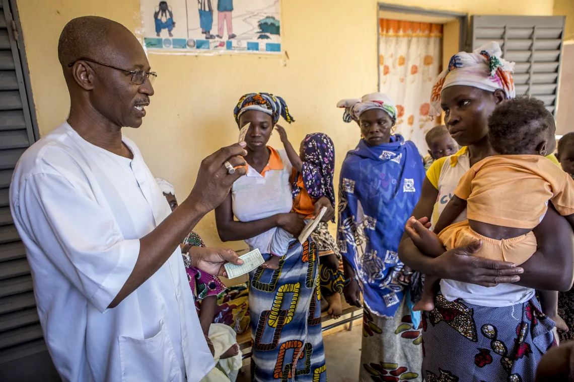 Zoumana Berthe directeur technique du centre DTC du CSCom de Sougoumba avec les femmes dans la cour du centre apr&egrave;s la consultation pour des conseils sur l&rsquo;hygi&egrave;ne. Village de Soungoumba, Commune rurale de Koningu&eacute;, r&eacute;gion de Sikasso, Mali, Octobre 2019.