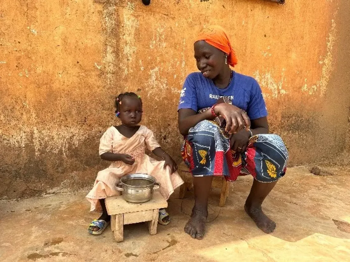 Kadia, une maman refugi&eacute;e Burkinabaise, &acirc;g&eacute;e de 25 ans, ici avec sa fille Mariam, &acirc;g&eacute;e de deux ans et demi dans la famille qui les accueille. Mariam compl&egrave;tement gu&eacute;rie prend son d&eacute;jeuner avec app&eacute;tit.