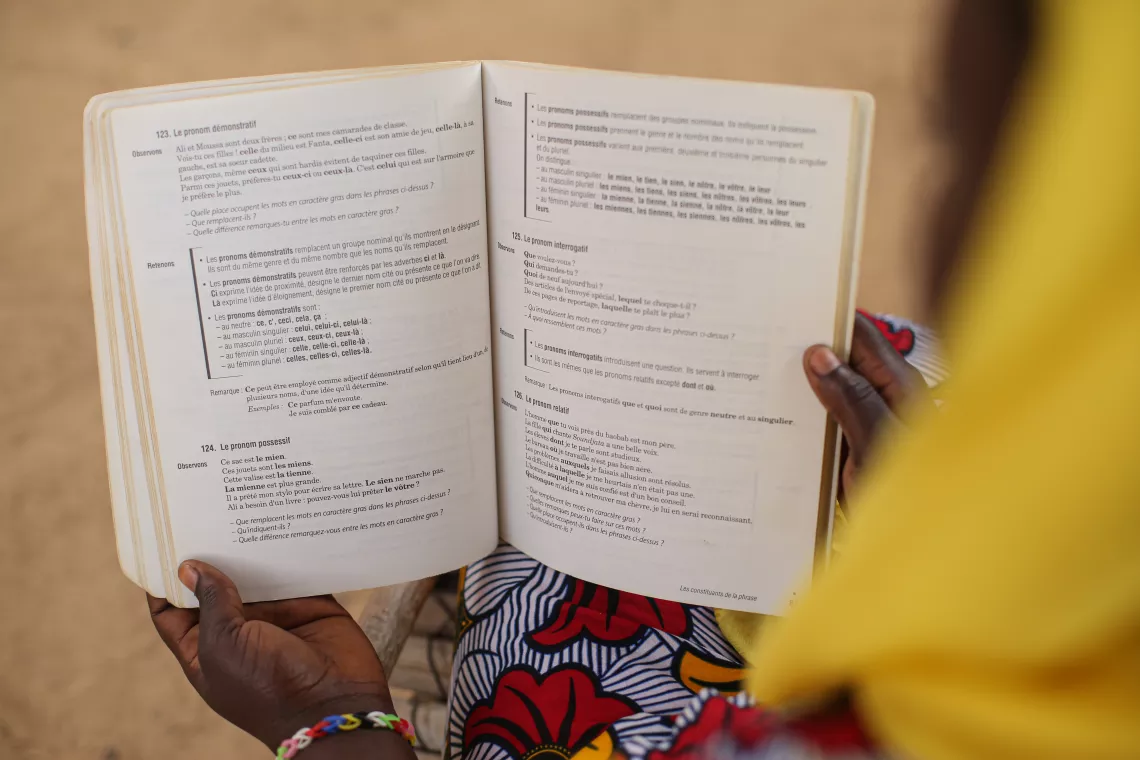 Hawa (nom d'emprunt) &eacute;tudiante de 17 ans au lyc&eacute;e de Bafoulab&eacute; est en train de lire un livre de grammaire dans la cour de son logement.