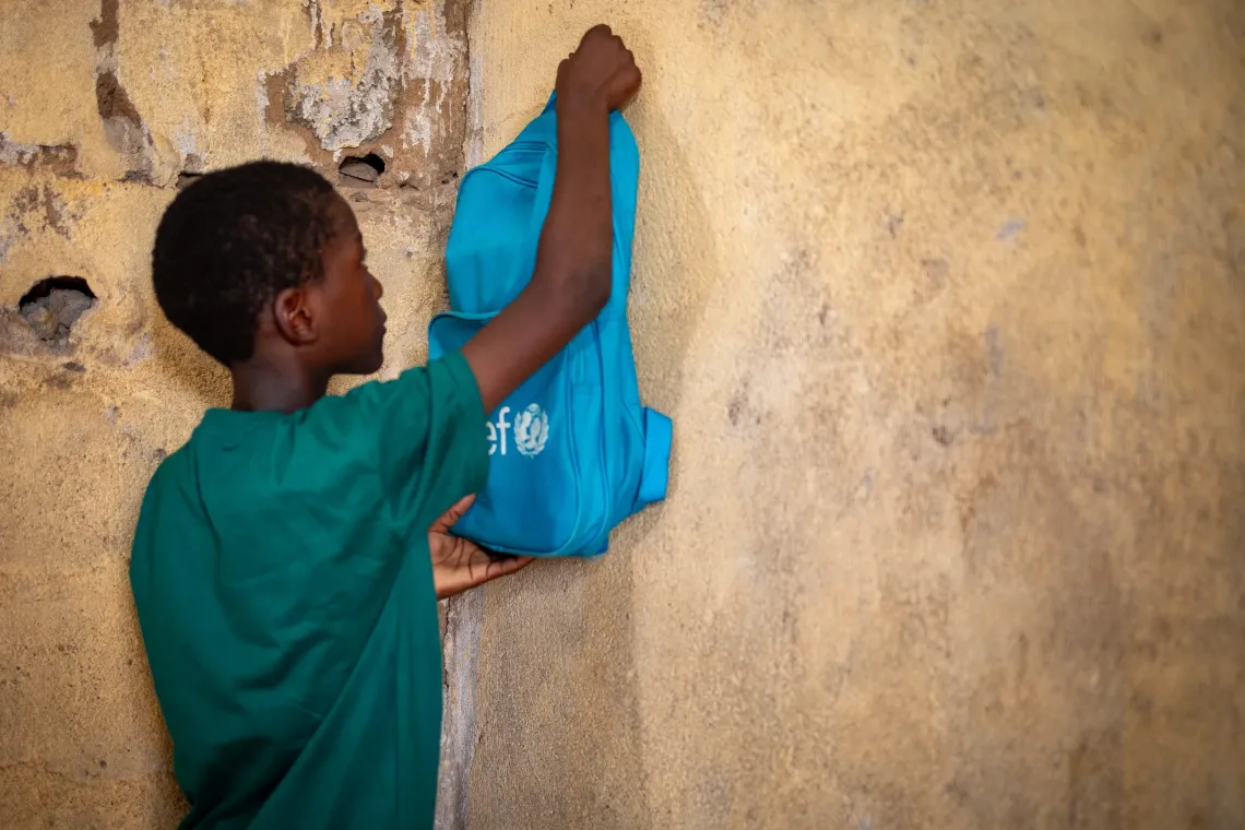 Mahamadou, 10 ans, pr&eacute;pare son sac chez lui avant de partir &agrave; l'&eacute;cole.