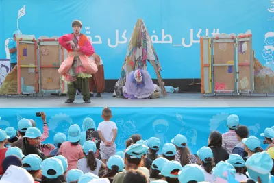 a clown performing on a stage in front of kids