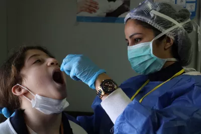  a health worker giving a vaccine to a child both having masks