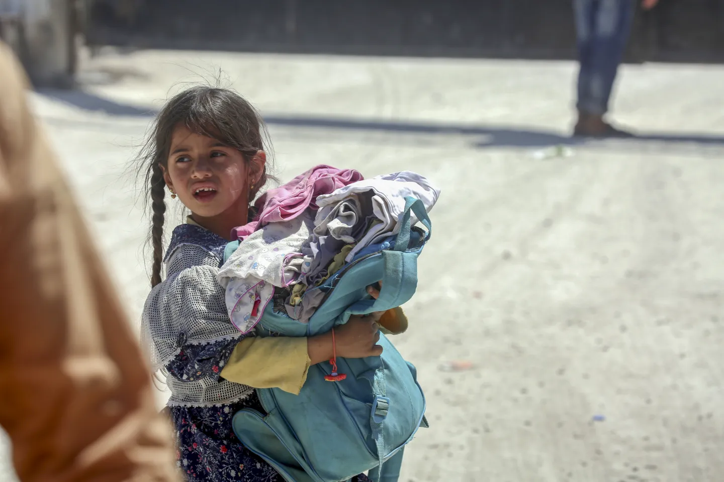 Young girl holding her belongings and walking 