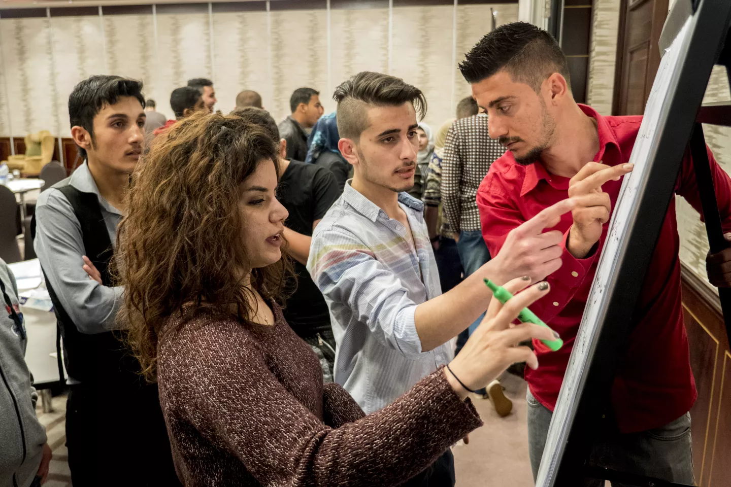 Youth writing on a board in a conference