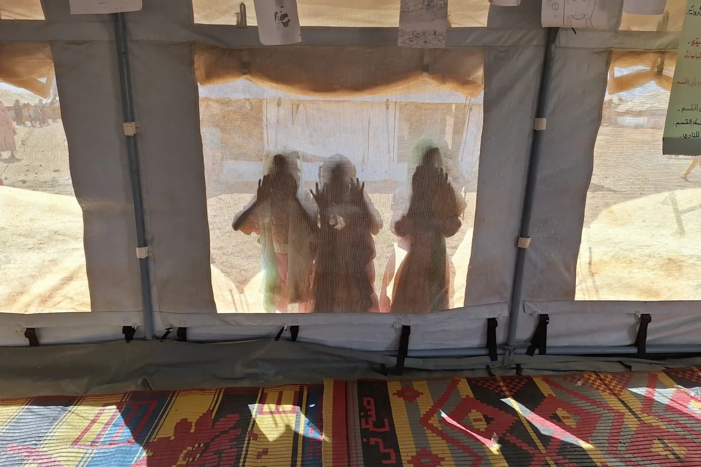 On 3 December 2024, children peer through a UNICEF tent at a child-friendly space (CFS) in Kassala state, Sudan. 