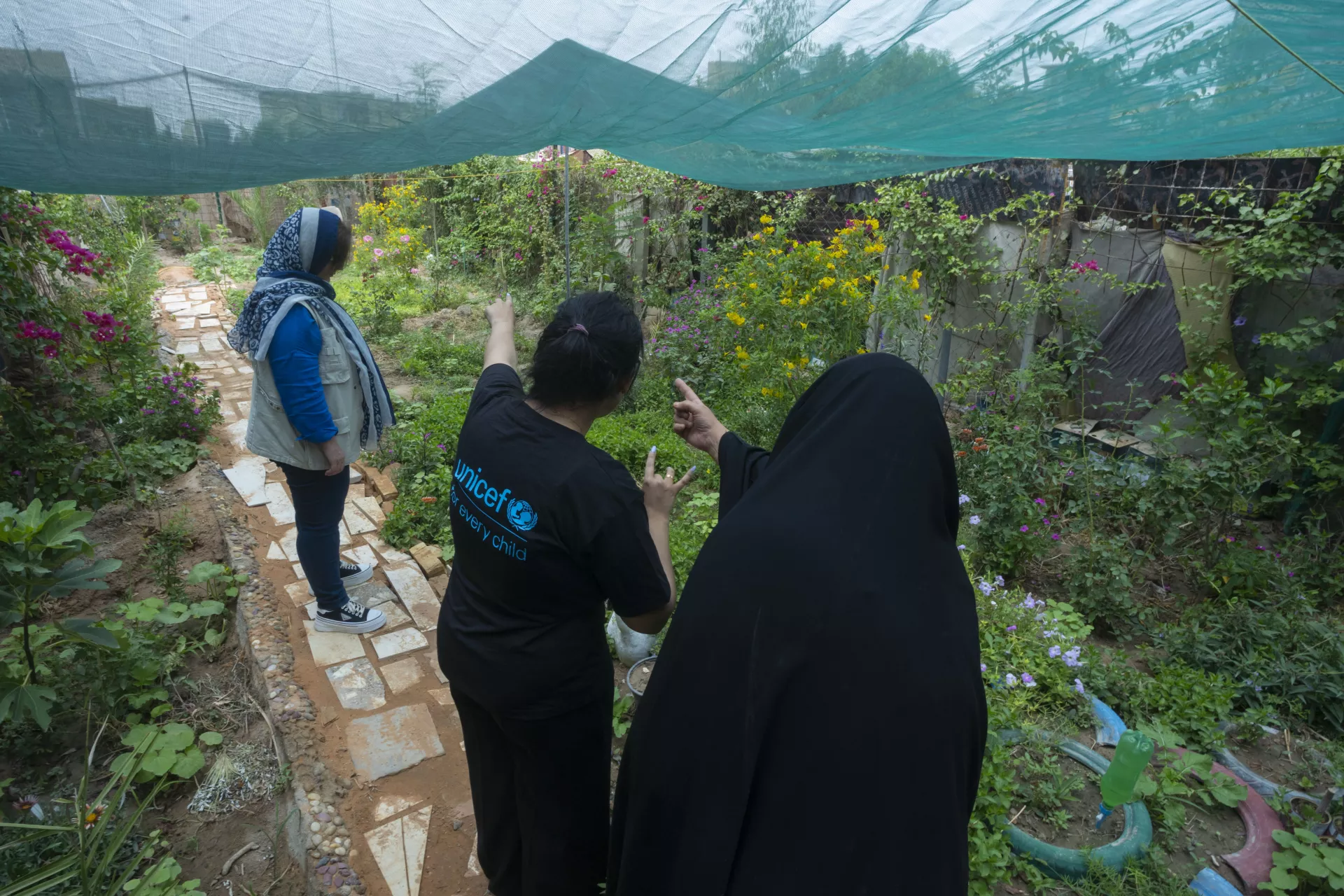 58-year old Laila* is showing the UNICEF team her plants that she is growing at her plant nursery.