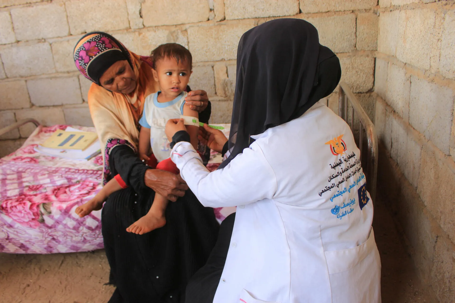 Health worker using MUAC on a child