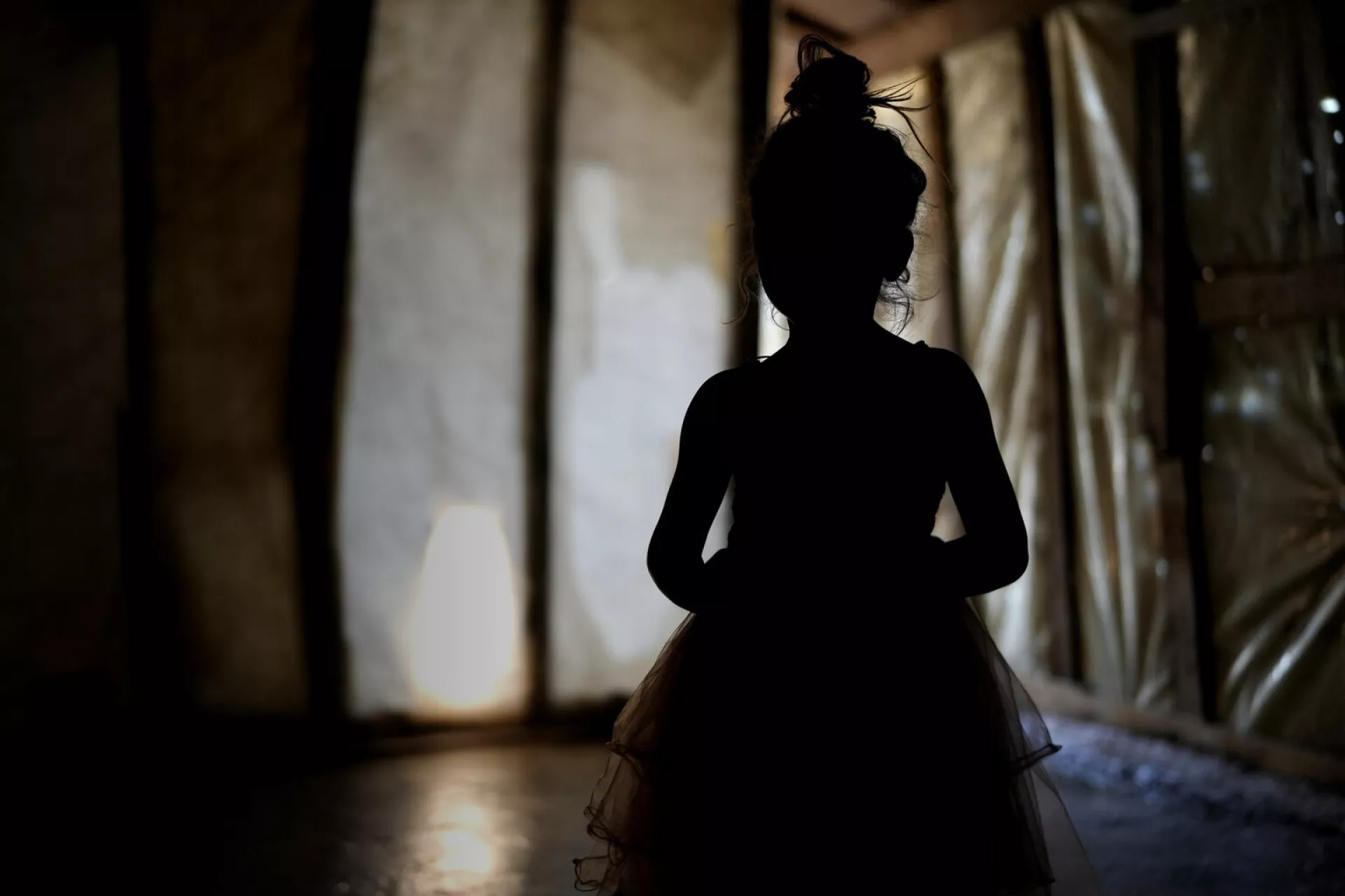 a silhouette of a girl in a tent