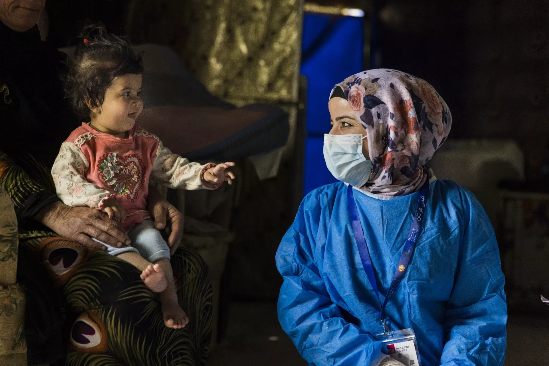 On 12 April 2022 in Ashti camp, Arbat City, Iraq, 10-month-old Shahad Mahmood (sitting in the lap of her grandmother) gets ready to receive a routine immunisation at her home.