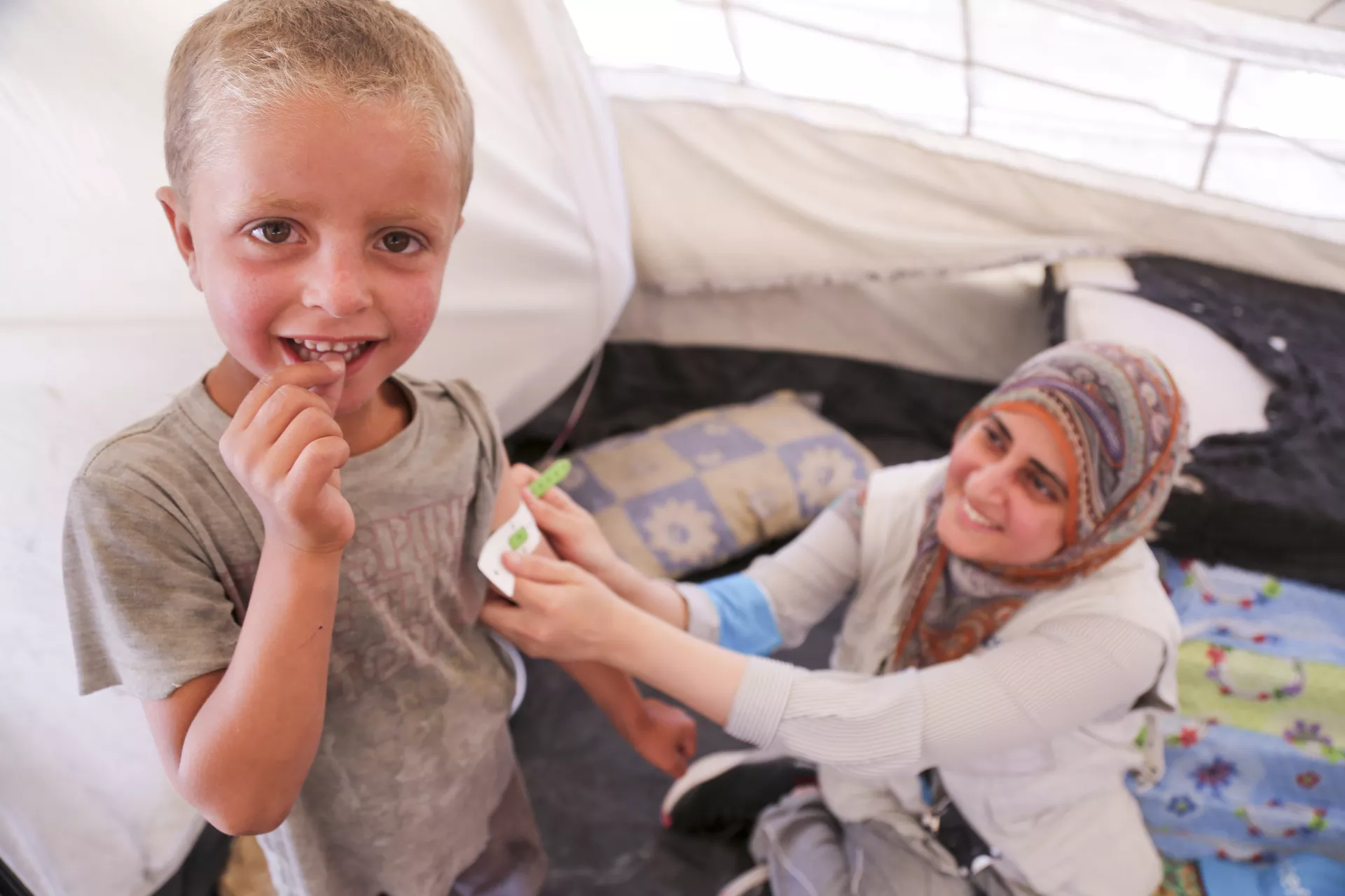 health worker measuring arm circumference of a child