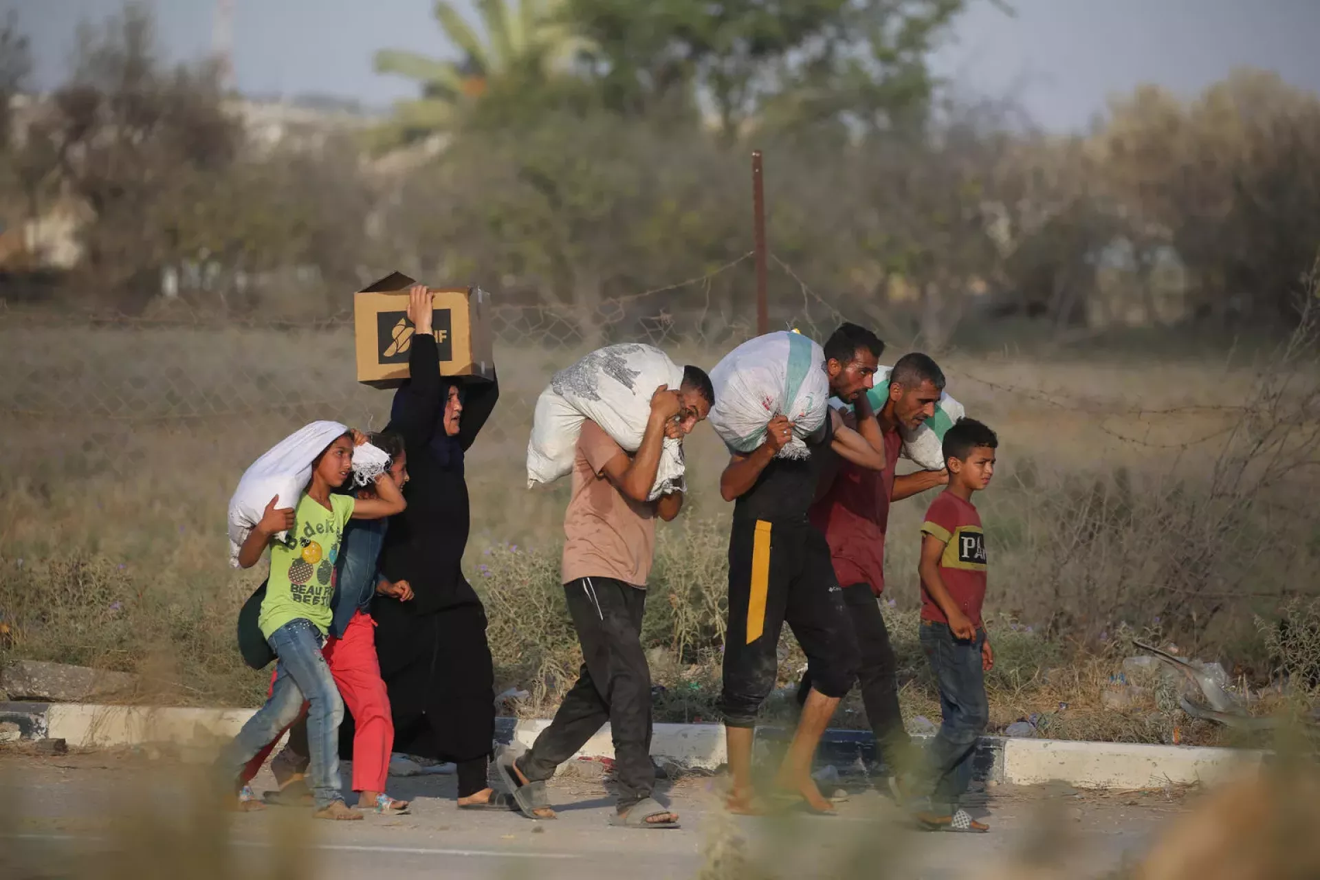 Gaza. Children and adults carry supplies near a distribution point at Netzarim, the Gaza Strip.