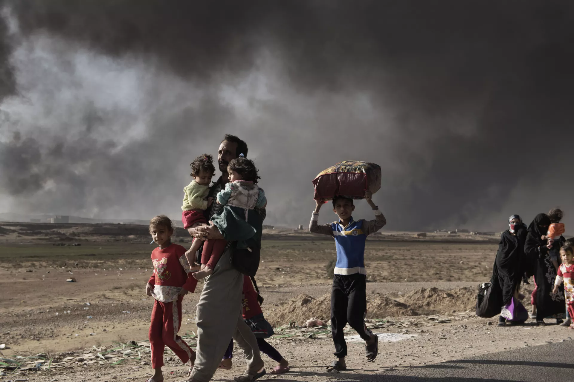 displaced man carries two children