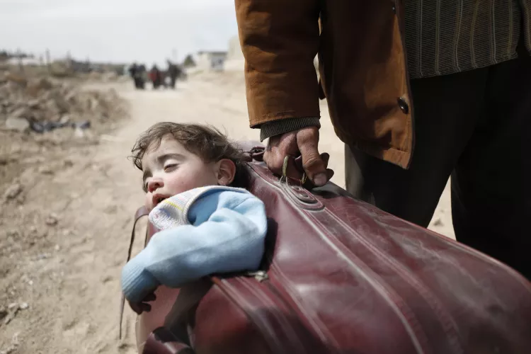 A man carrying his son in a suite case