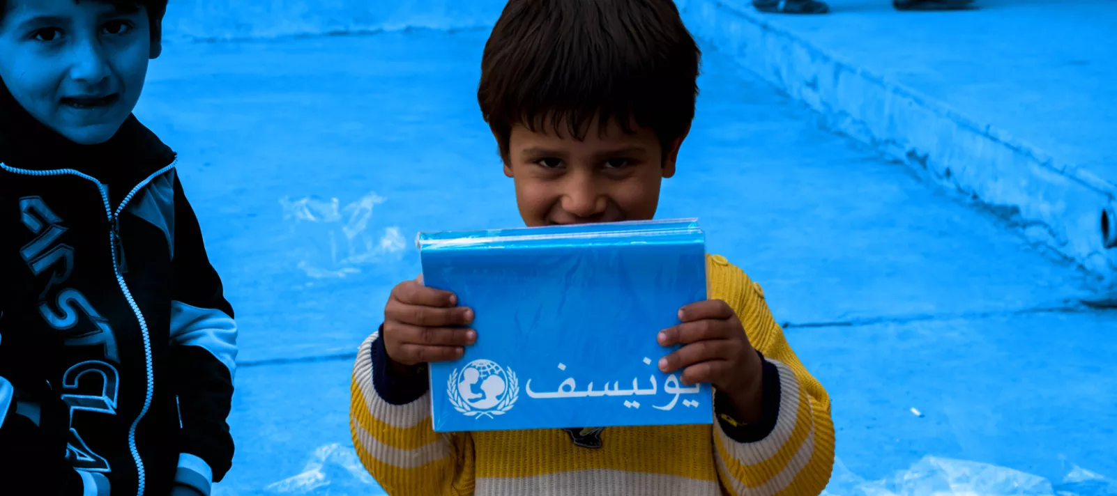 A child holding a UNICEF branded notebook