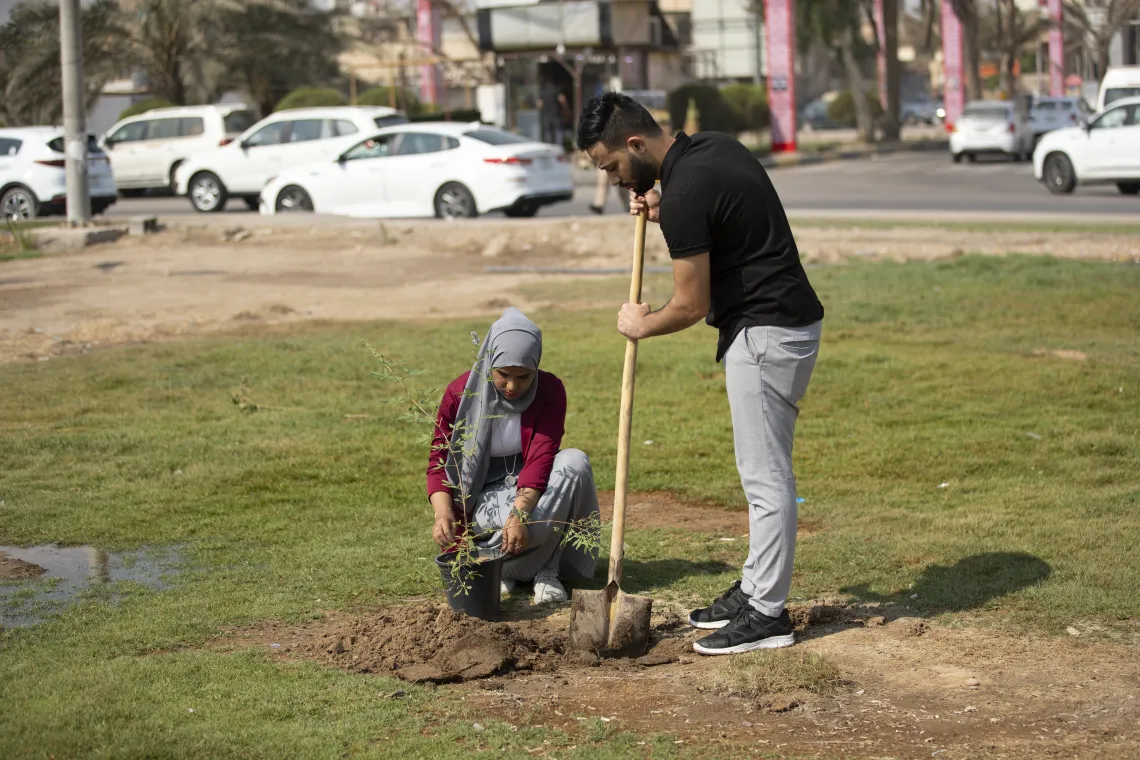 Fatima and Abdul Aleem in the aviation yard in the center of Basra to grow seedlings