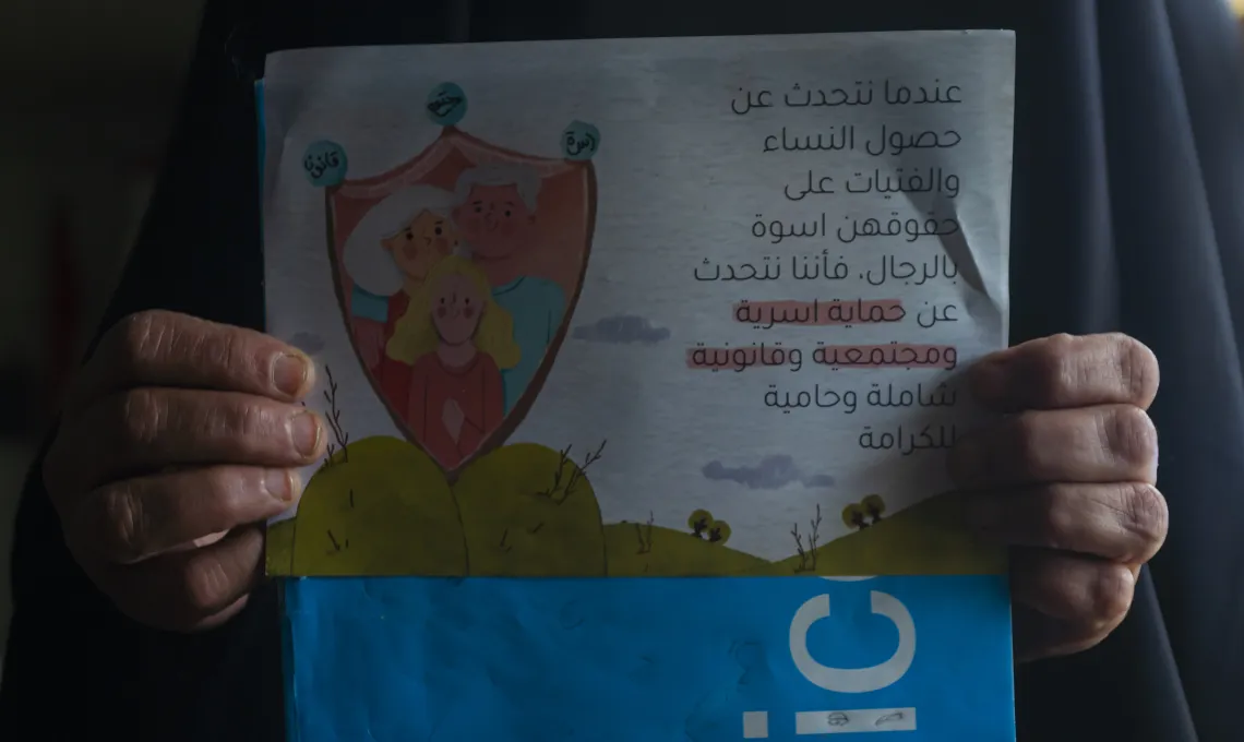 Laila*, 58, a gender-based violence survivor is showing us the brochure that she initially received from the women&rsquo;s center in Al Najaf.