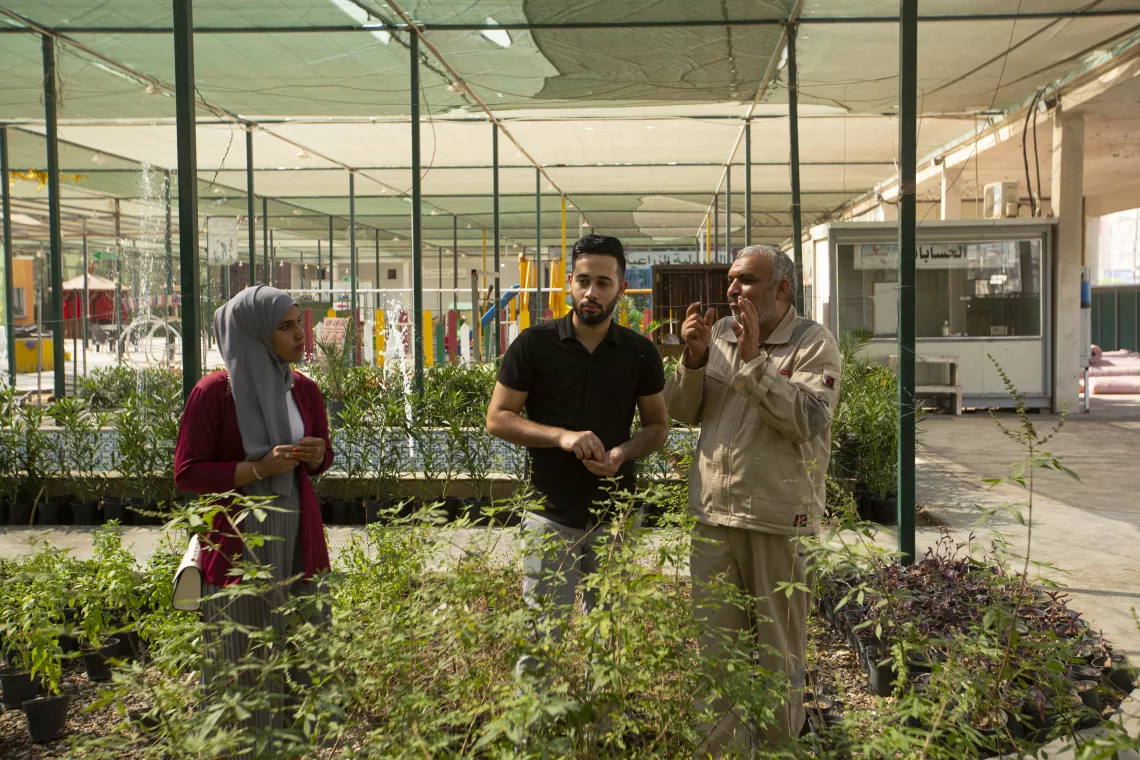 A farmer explains to Abdel Aleem and Fatima the correct way to farm
