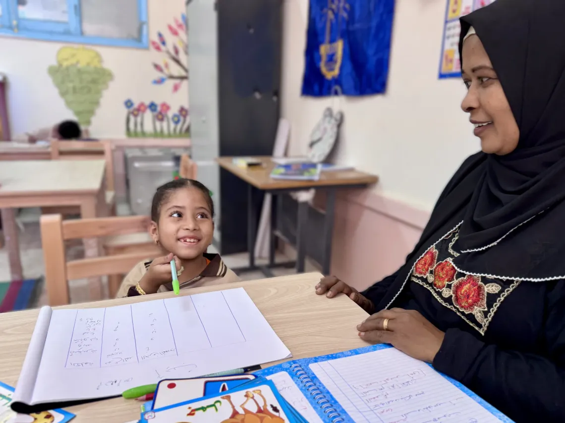 Malak and her teacher in a classroom