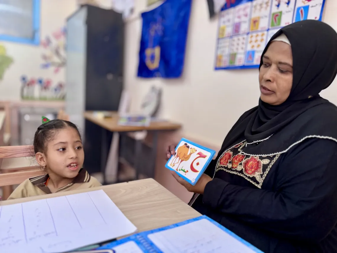 Malak and her teacher in a classroom