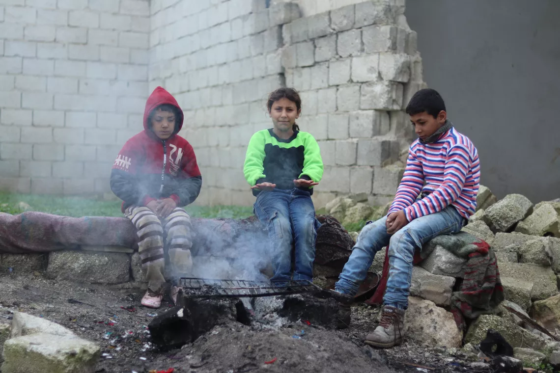 Children sitting around a fire 