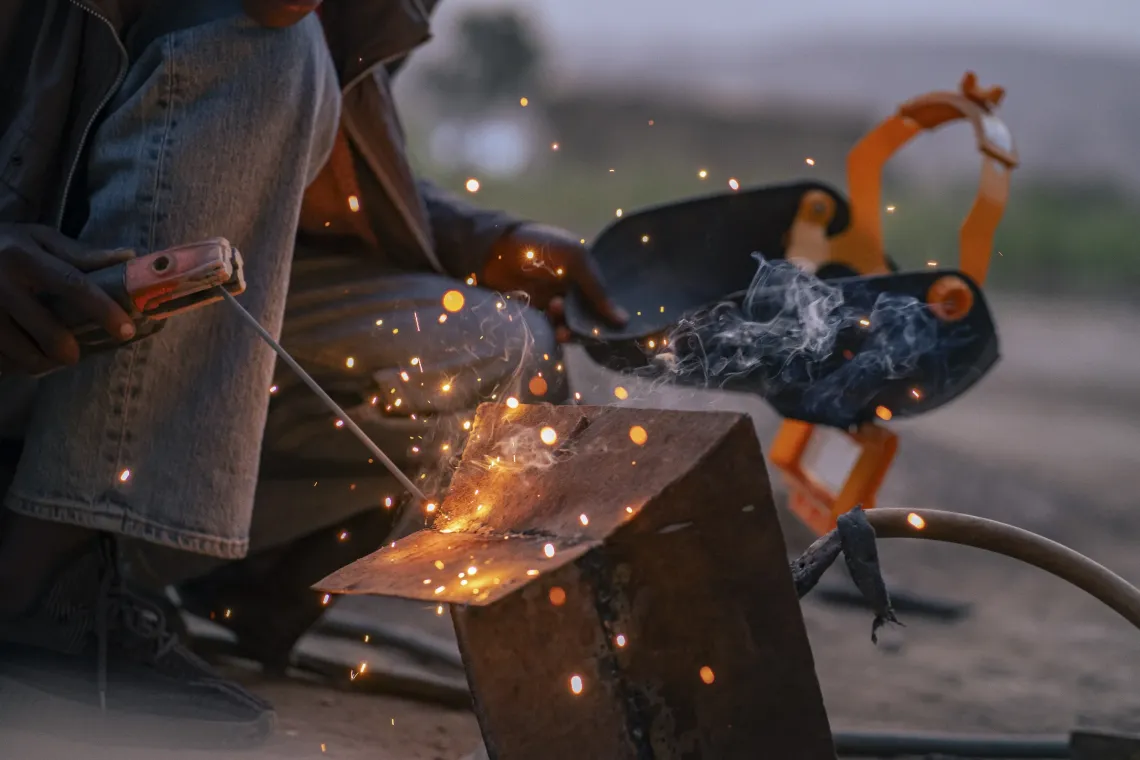 Bright sparks jump as Astride uses a brazier while welding in the courtyard.