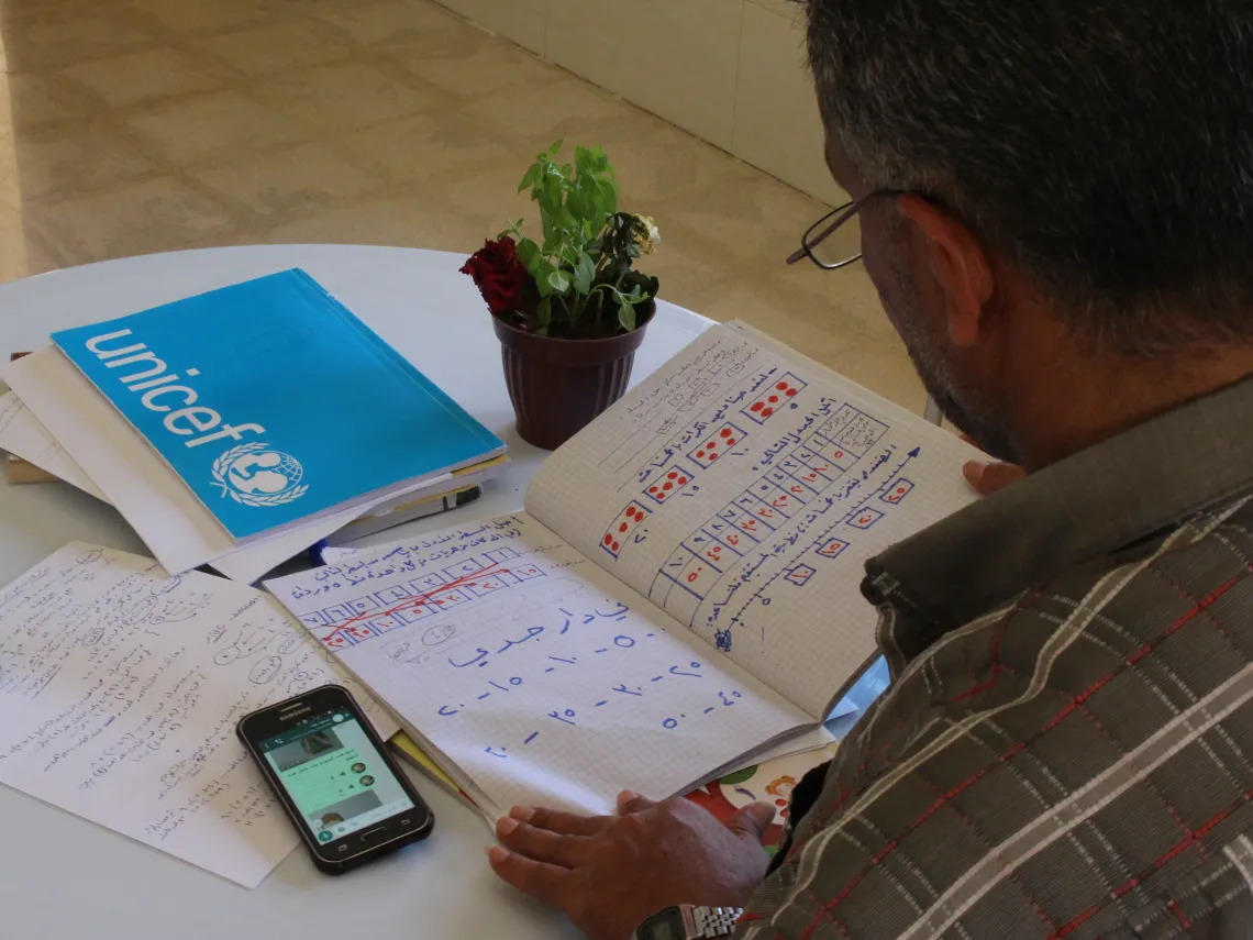a teacher checking a notebook