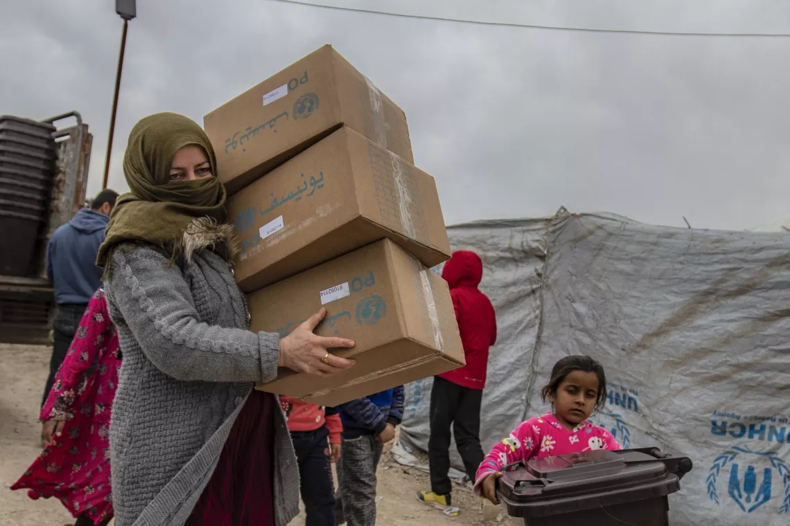 Children and families receive new clothing kits distributed by UNICEF in Roj camp, northeastern Syria.