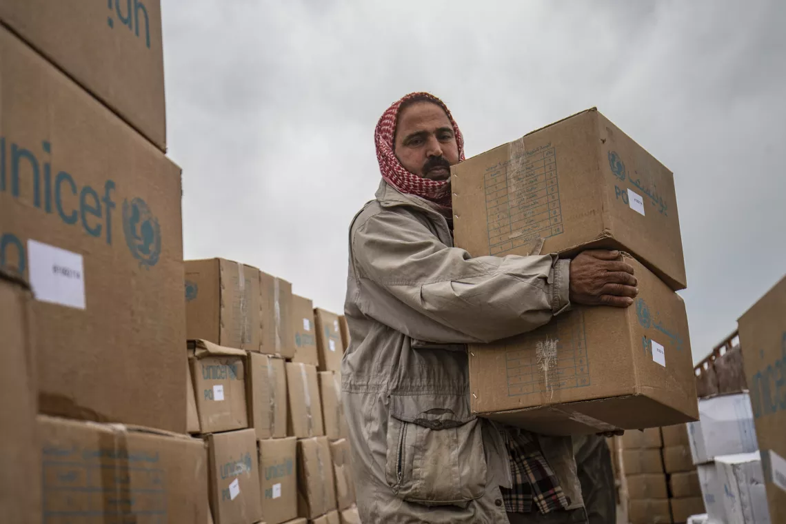 Children and families receive new clothing kits distributed by UNICEF in Roj camp, northeastern Syria.