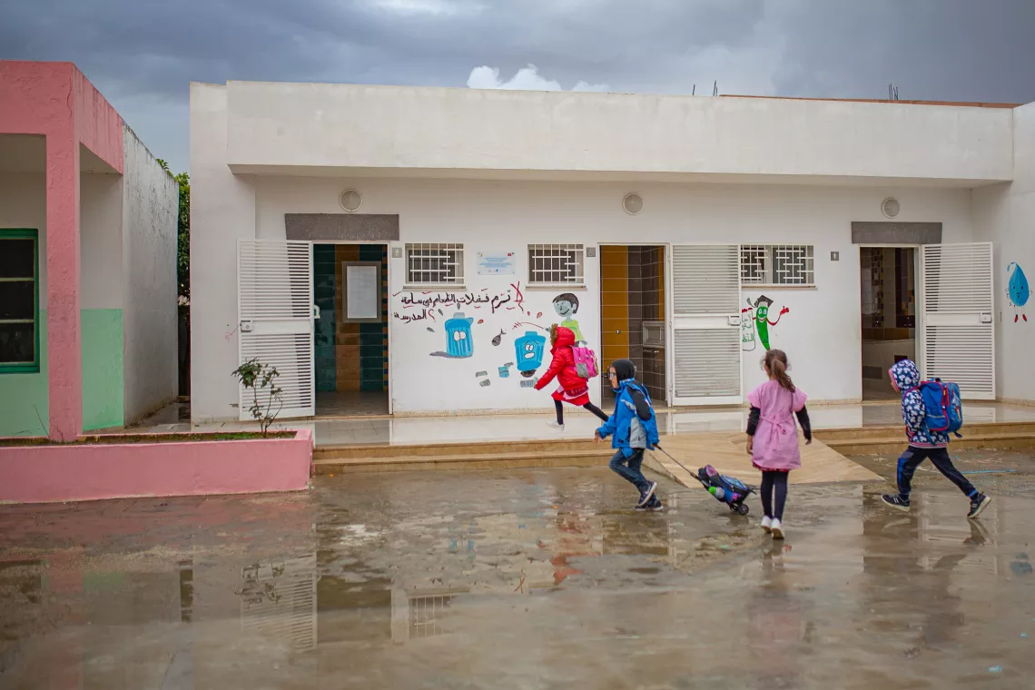 Students run towards the sanitary block on a rainy day in Zouaouine. To the left are the boys&rsquo; facilities, on the right the girls&rsquo; facilities, and in the middle is the block designated for disabled students. All are perfectly equipped. /Zouaouine, Bizerte. 