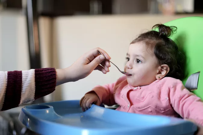 Child fed by her parent cereal 