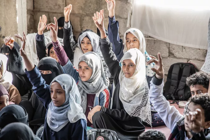 Kholood, raises her hand to answer the teacher's question during her class, Taizz, Yemen, 2021.