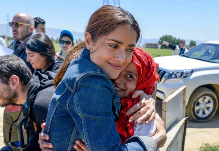 Salma Hayek hugging a Syrian refugee