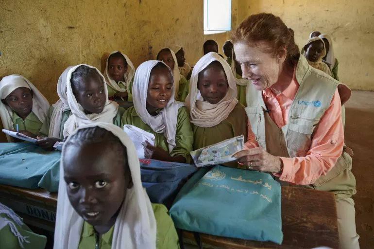 UNICEF Executive Director sitting with students in class