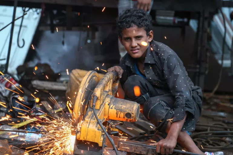 12-year-old Anas cuts iron in a workshop, Taizz, Yemen September, 2020.